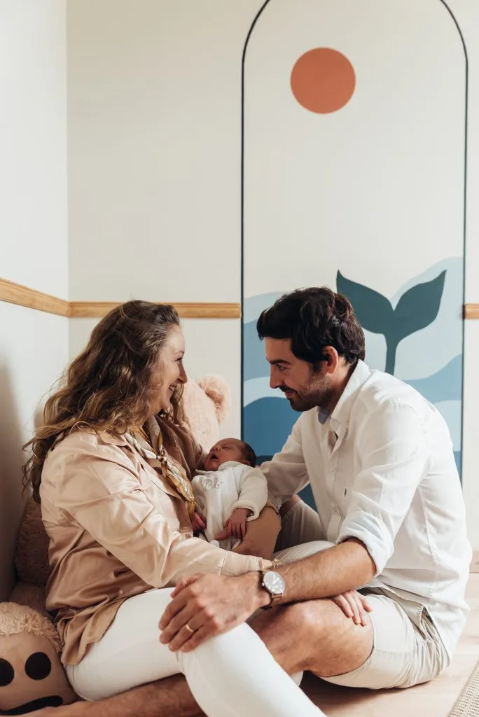Jeune parents avec leur nouveau-né lors d'une séance naissance à domicile